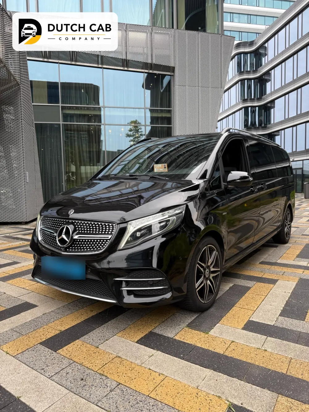 Zwarte Mercedes V-Klasse voor zakelijk vervoer bij een kantoorpand