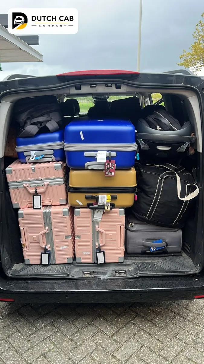 Kofferbak van een Dutch Cab Company minivan vol koffers en een kinderzitje